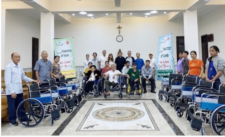 Wheelchairs Of Love — volunteer speaking with wheelchair recipient