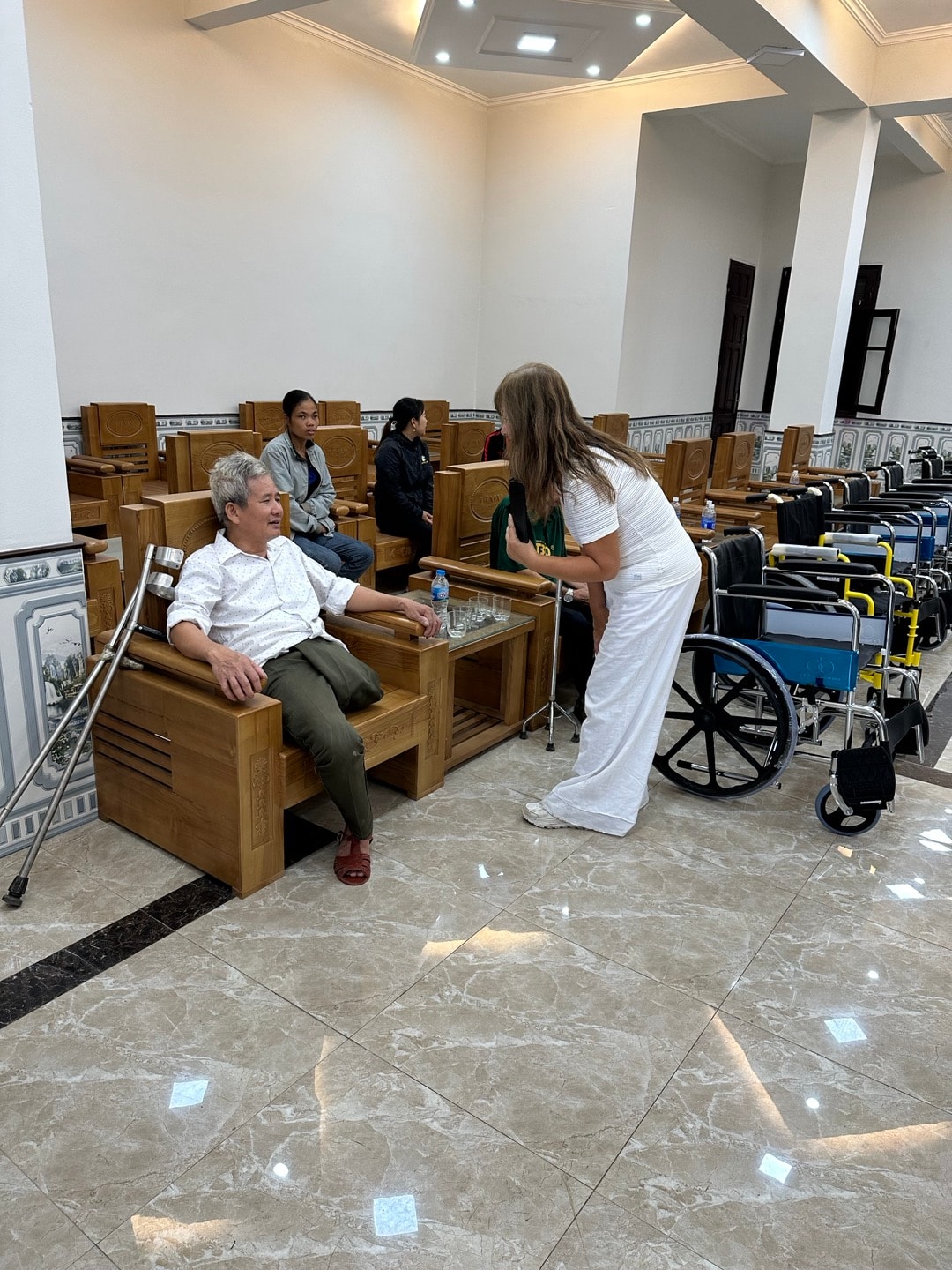 Wheelchairs Of Love — recipients receiving wheelchairs outdoors